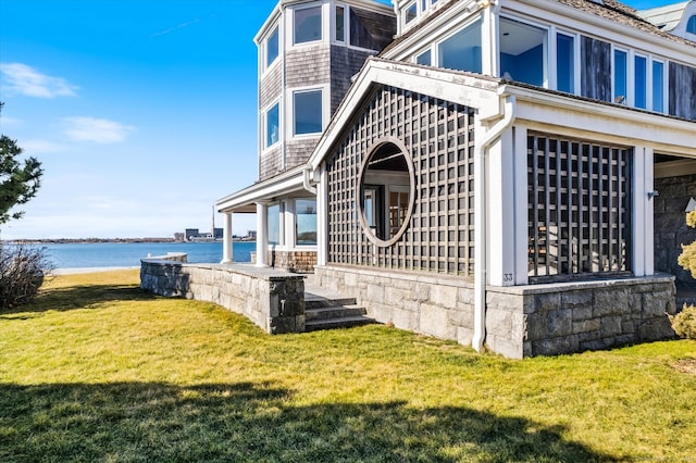 view of side of property featuring a lawn and a water view