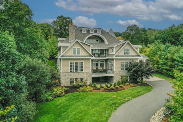 view of front of house featuring a balcony and a front yard