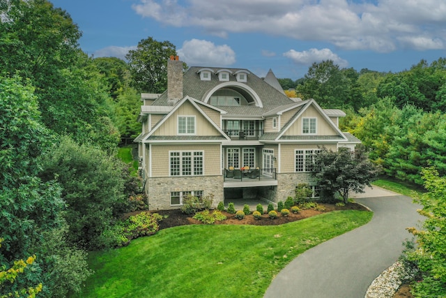 162 Balfour Dr, West Hartford, CT 06117 - view of front of house with a chimney, a balcony, a front lawn, asphalt driveway, and stone siding