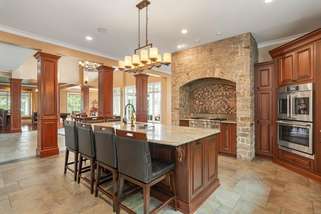 162 Balfour Dr, West Hartford, CT 06117 - kitchen with appliances with stainless steel finishes, decorative columns, a breakfast bar, stone tile flooring, and light stone counters