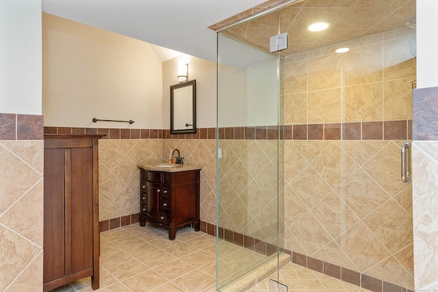 162 Balfour Dr, West Hartford, CT 06117 - bathroom with tile walls, a stall shower, vanity, wainscoting, and tile patterned floors