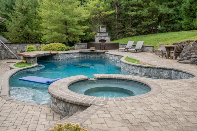 162 Balfour Dr, West Hartford, CT 06117 - view of swimming pool featuring an outdoor stone fireplace, a patio, a pool with connected hot tub, a yard, and a wooded view