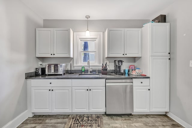 kitchen featuring stainless steel dishwasher, sink, and white cabinets