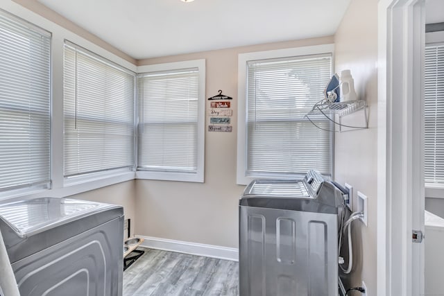 laundry area with light wood-type flooring and independent washer and dryer