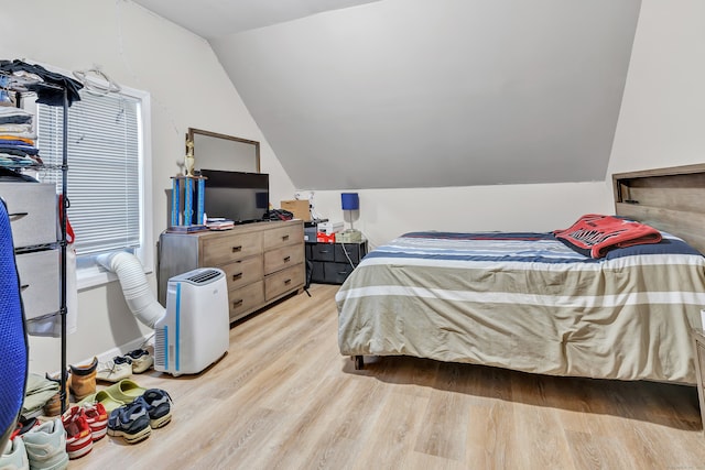 bedroom with vaulted ceiling and light hardwood / wood-style floors