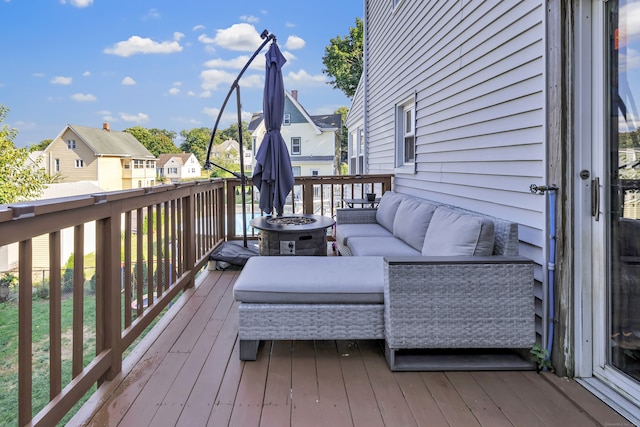 wooden terrace featuring an outdoor living space with a fire pit