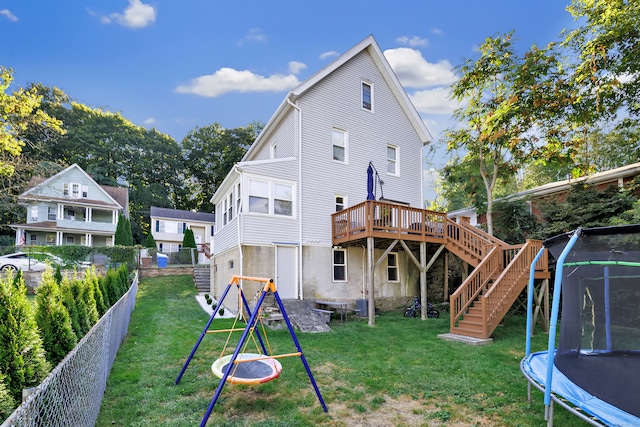 back of property featuring a yard, central AC unit, a trampoline, and a deck