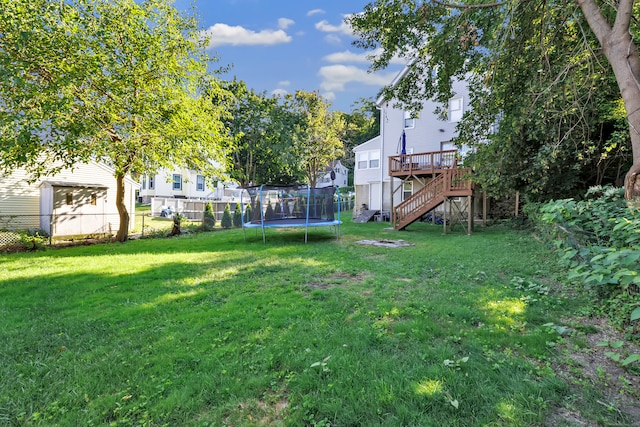 view of yard featuring a trampoline and a deck