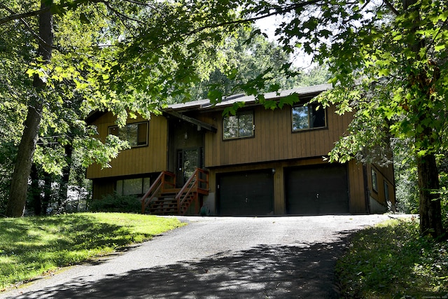 raised ranch with a garage and a front yard