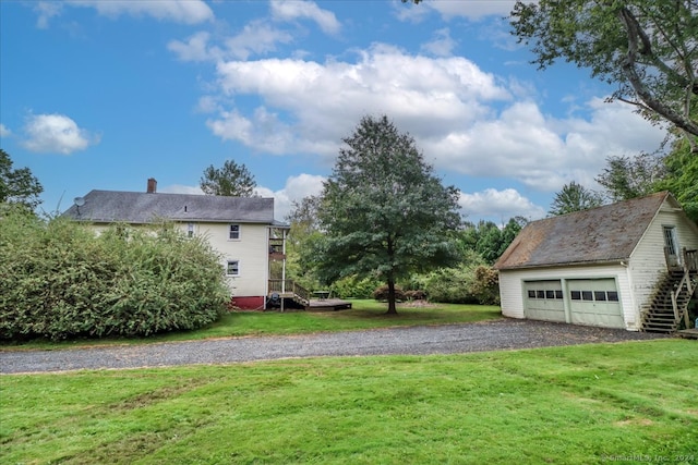 view of yard featuring a garage and an outbuilding