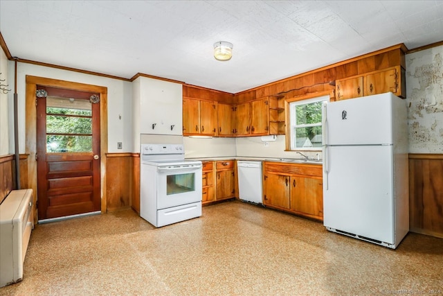 kitchen featuring wood walls, sink, white appliances, and crown molding