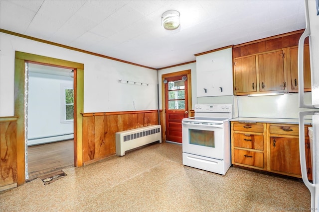 kitchen with radiator heating unit, electric range, wooden walls, and a healthy amount of sunlight