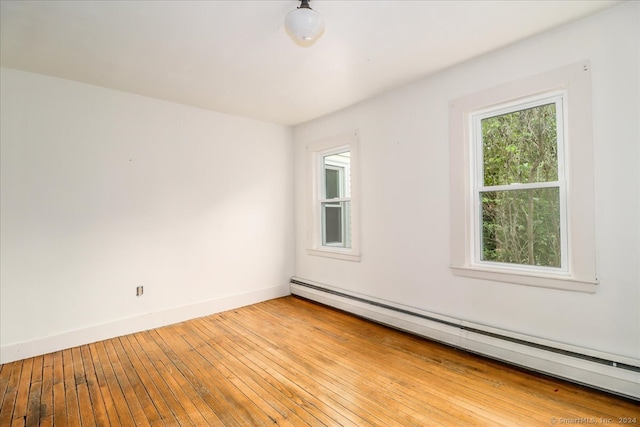 spare room featuring a baseboard radiator and light hardwood / wood-style floors