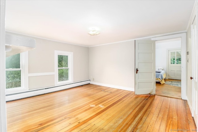 empty room featuring a baseboard radiator, hardwood / wood-style flooring, and ornamental molding