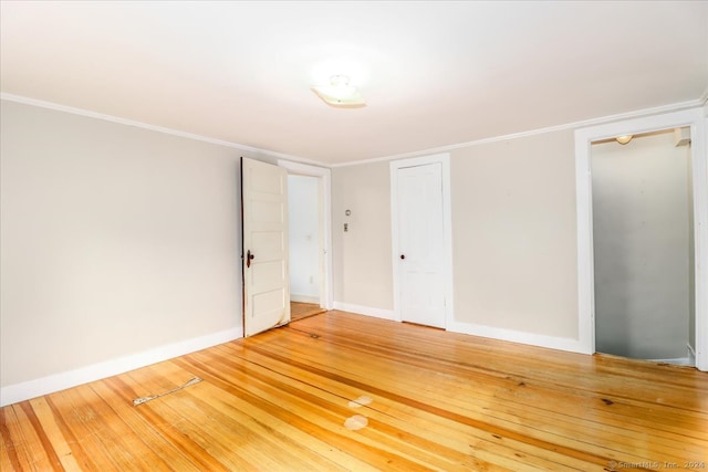 unfurnished room featuring wood-type flooring and ornamental molding