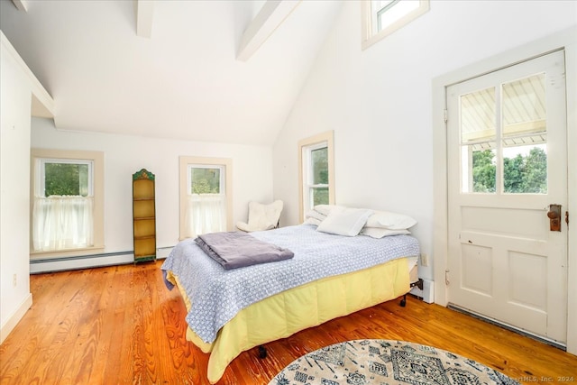 bedroom featuring wood-type flooring, lofted ceiling with beams, a baseboard radiator, and multiple windows