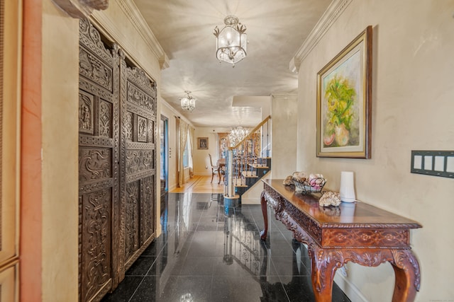 hallway featuring crown molding, granite finish floor, stairway, baseboards, and a chandelier