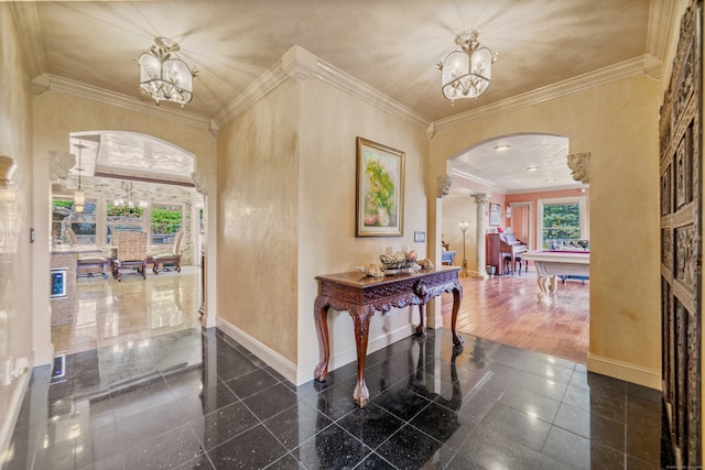 foyer featuring an inviting chandelier, arched walkways, baseboards, and granite finish floor