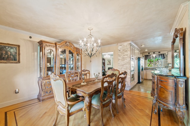 dining area with light wood-type flooring, crown molding, and an inviting chandelier