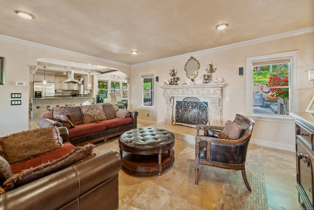 living room featuring a premium fireplace, plenty of natural light, and crown molding