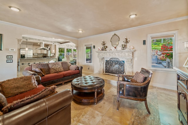 living room with baseboards, ornamental molding, and a fireplace
