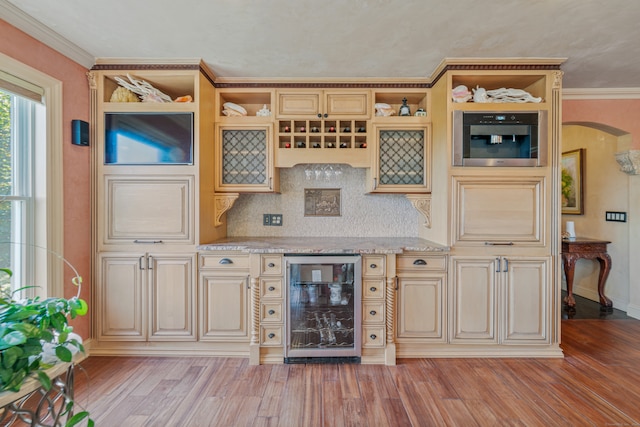 bar featuring light stone counters, wine cooler, tasteful backsplash, light hardwood / wood-style flooring, and ornamental molding