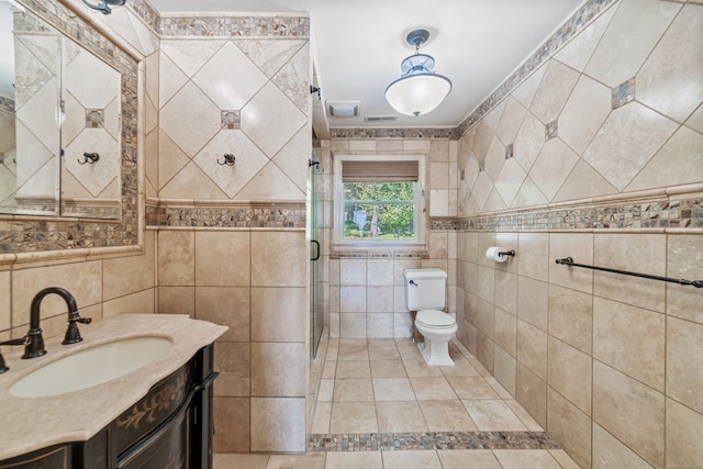 bathroom with walk in shower, tile walls, vanity, and toilet