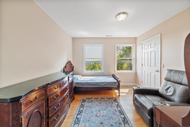 bedroom featuring baseboards, visible vents, and light wood-style flooring
