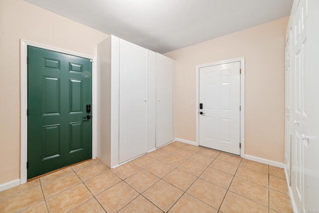 entryway with baseboards and light tile patterned floors