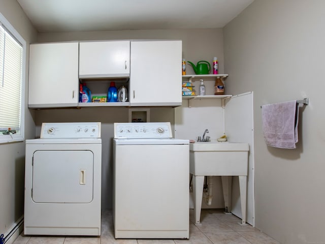 laundry area featuring cabinets, a baseboard radiator, light tile patterned floors, and washing machine and dryer