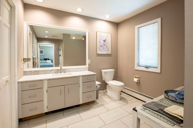 bathroom with curtained shower, vanity, toilet, and a baseboard heating unit