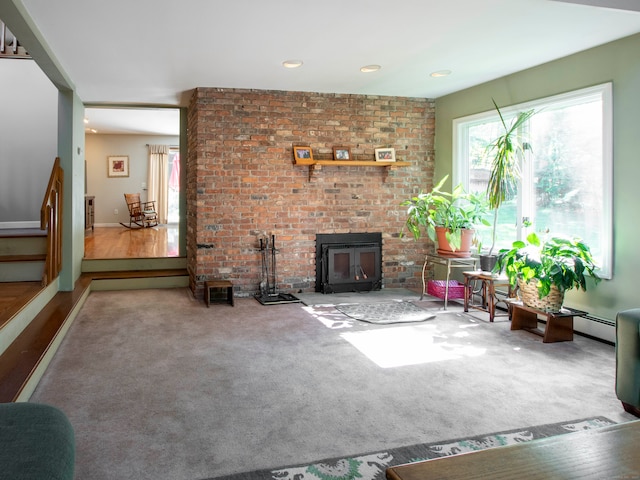 unfurnished living room with wood-type flooring, a wood stove, and a baseboard radiator