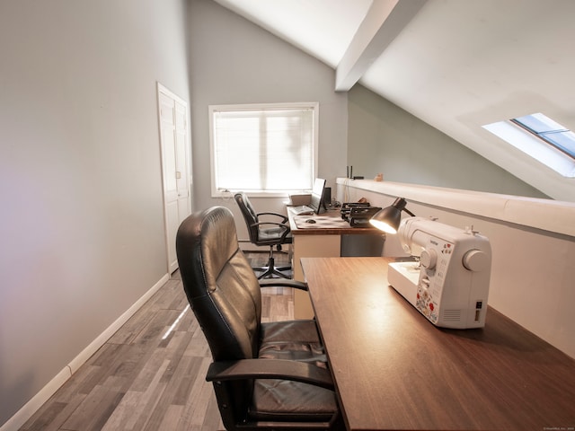 office area with hardwood / wood-style flooring and vaulted ceiling with skylight