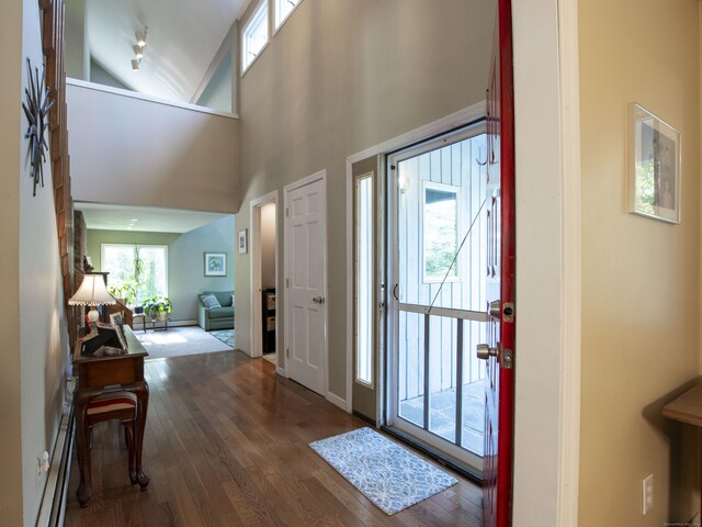 entryway featuring hardwood / wood-style floors, a baseboard heating unit, and high vaulted ceiling