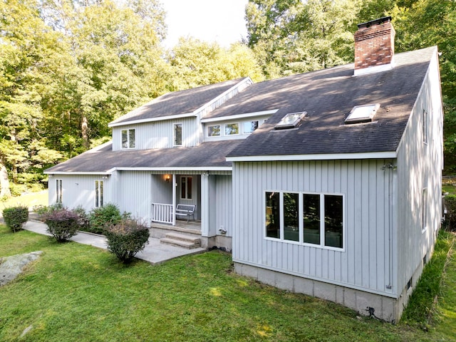 back of house with a yard and covered porch