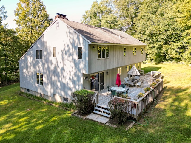 rear view of property featuring a deck and a yard