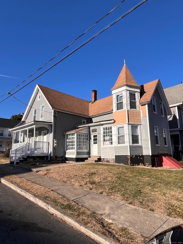 view of front of home with covered porch and a front yard