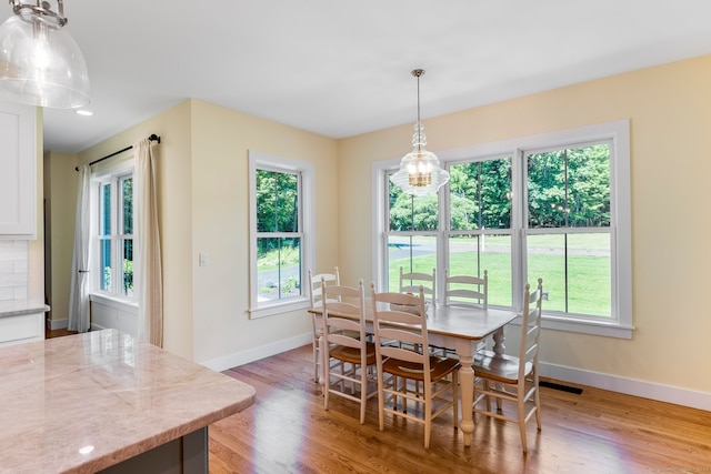 dining area with hardwood / wood-style floors and an inviting chandelier