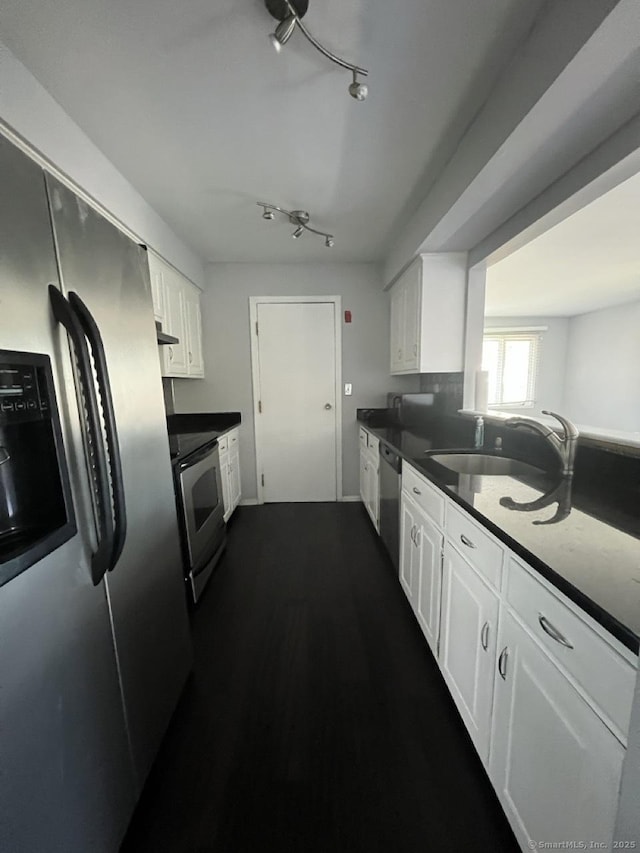 kitchen with white cabinets, dark countertops, and appliances with stainless steel finishes