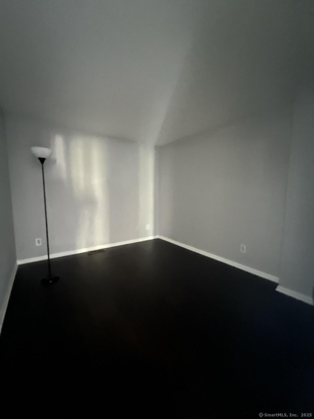 unfurnished room with baseboards