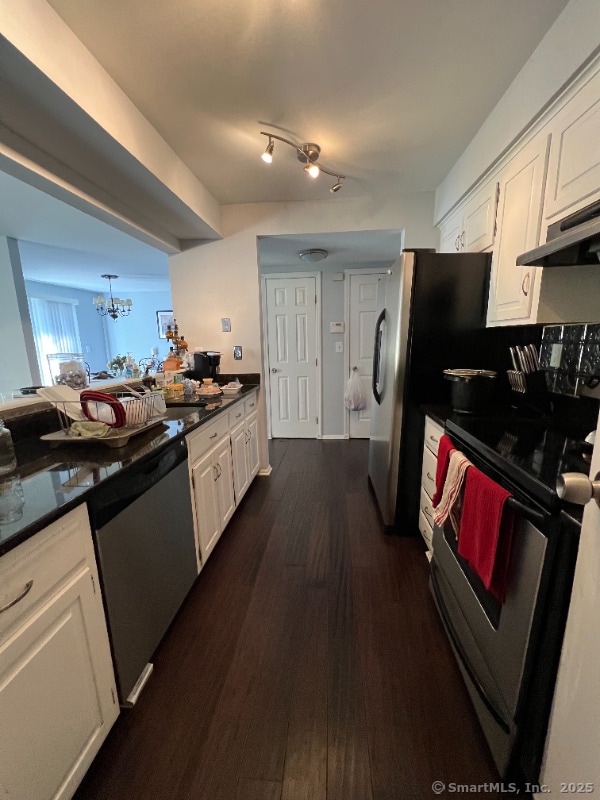 kitchen featuring white cabinetry, appliances with stainless steel finishes, under cabinet range hood, and dark countertops