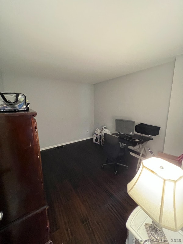 home office featuring baseboards and wood finished floors