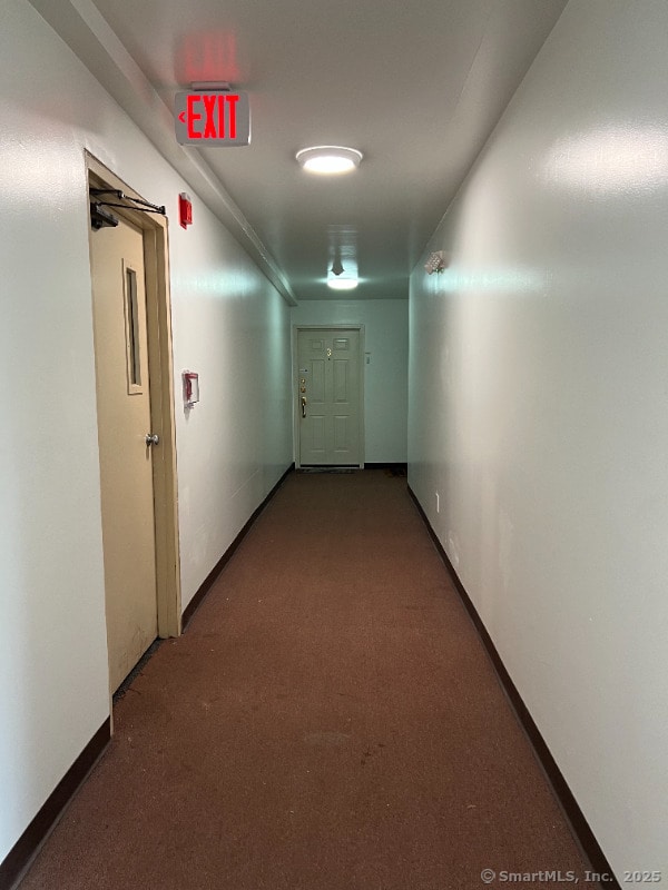 hall with baseboards and carpet