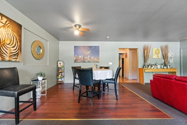 dining space featuring ceiling fan and dark wood-type flooring