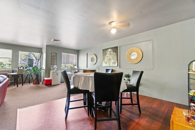 carpeted dining space with ceiling fan