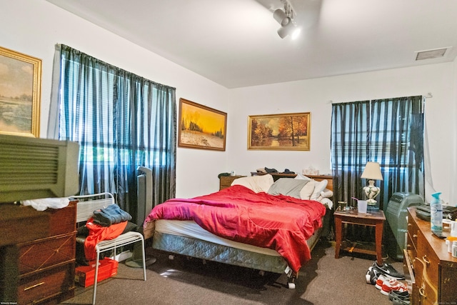 carpeted bedroom featuring track lighting