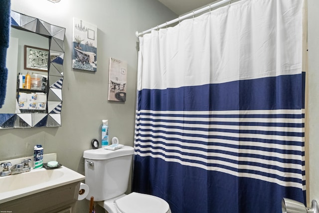 bathroom featuring walk in shower, vanity, and toilet