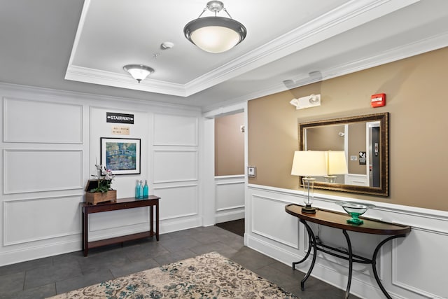 tiled entrance foyer with a raised ceiling and ornamental molding