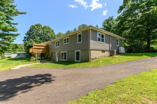 view of front of house with a front yard and central AC