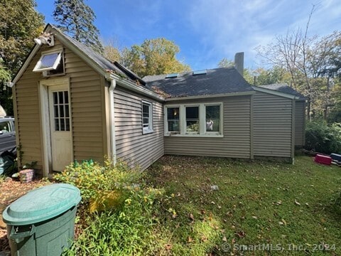 rear view of house featuring a yard